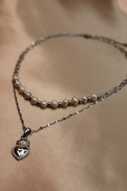 Una collana ad opera d'arte con perle di fiume e acciaio