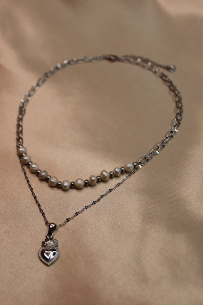 Una collana ad opera d'arte con perle di fiume e acciaio