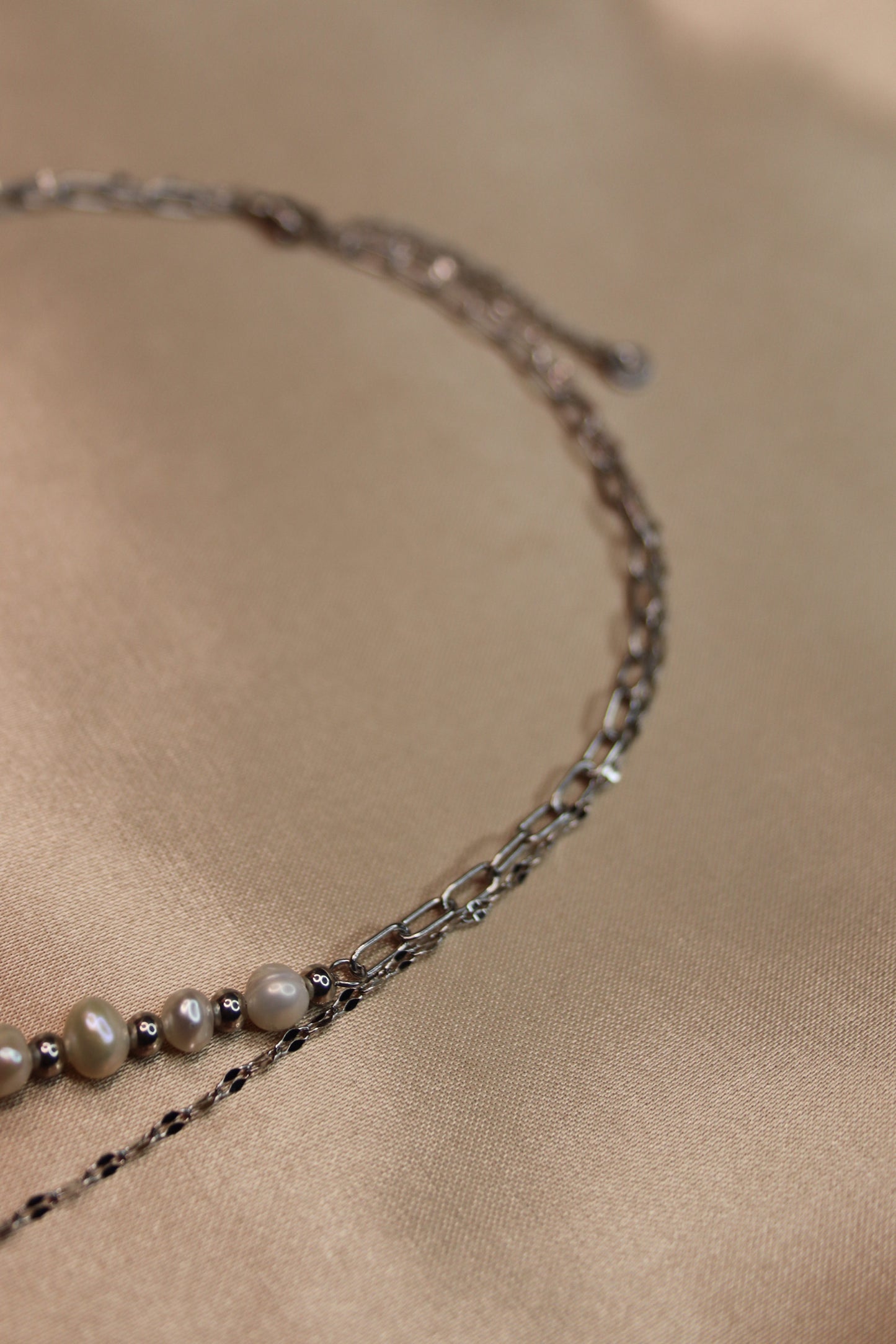 Una collana ad opera d'arte con perle di fiume e acciaio